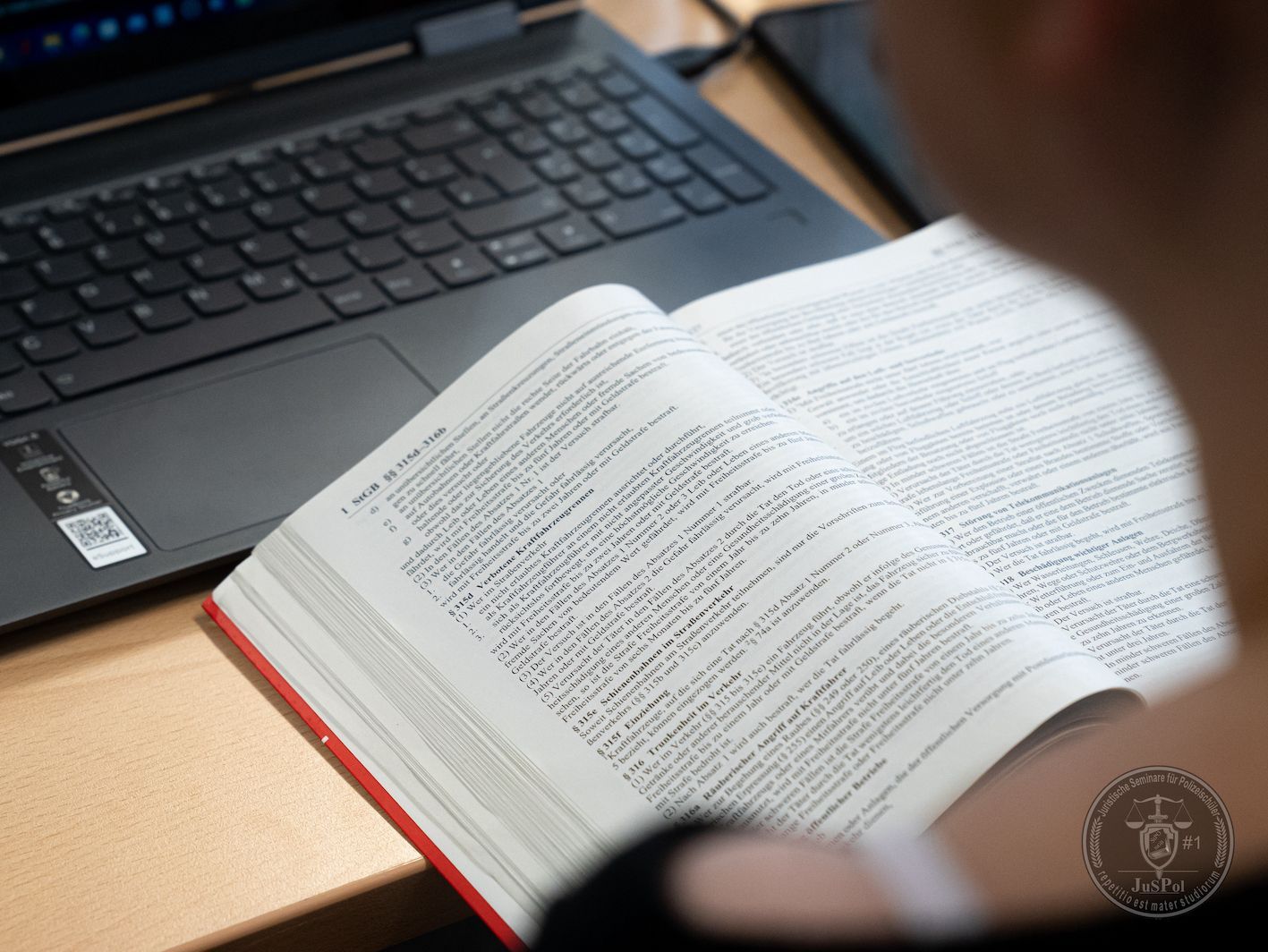 Aufgeschlagenes Gesetzbuch mit Paragraphen zu den §§ 113, 114 StGB und zur Belehrungspflicht bei der Identitätsfeststellung